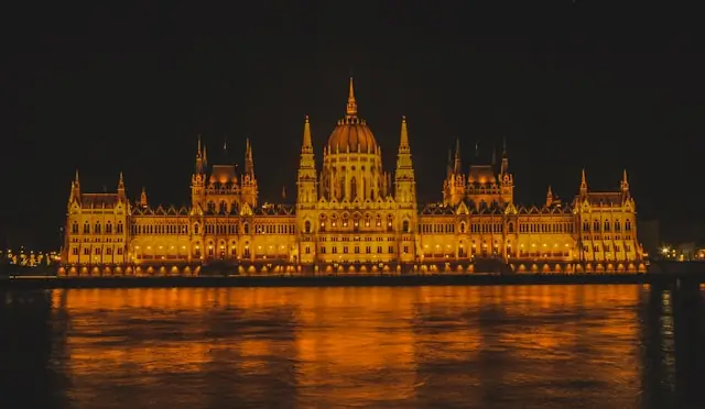 The Hungarian Parliament Building at night, reflecting on the Danube.